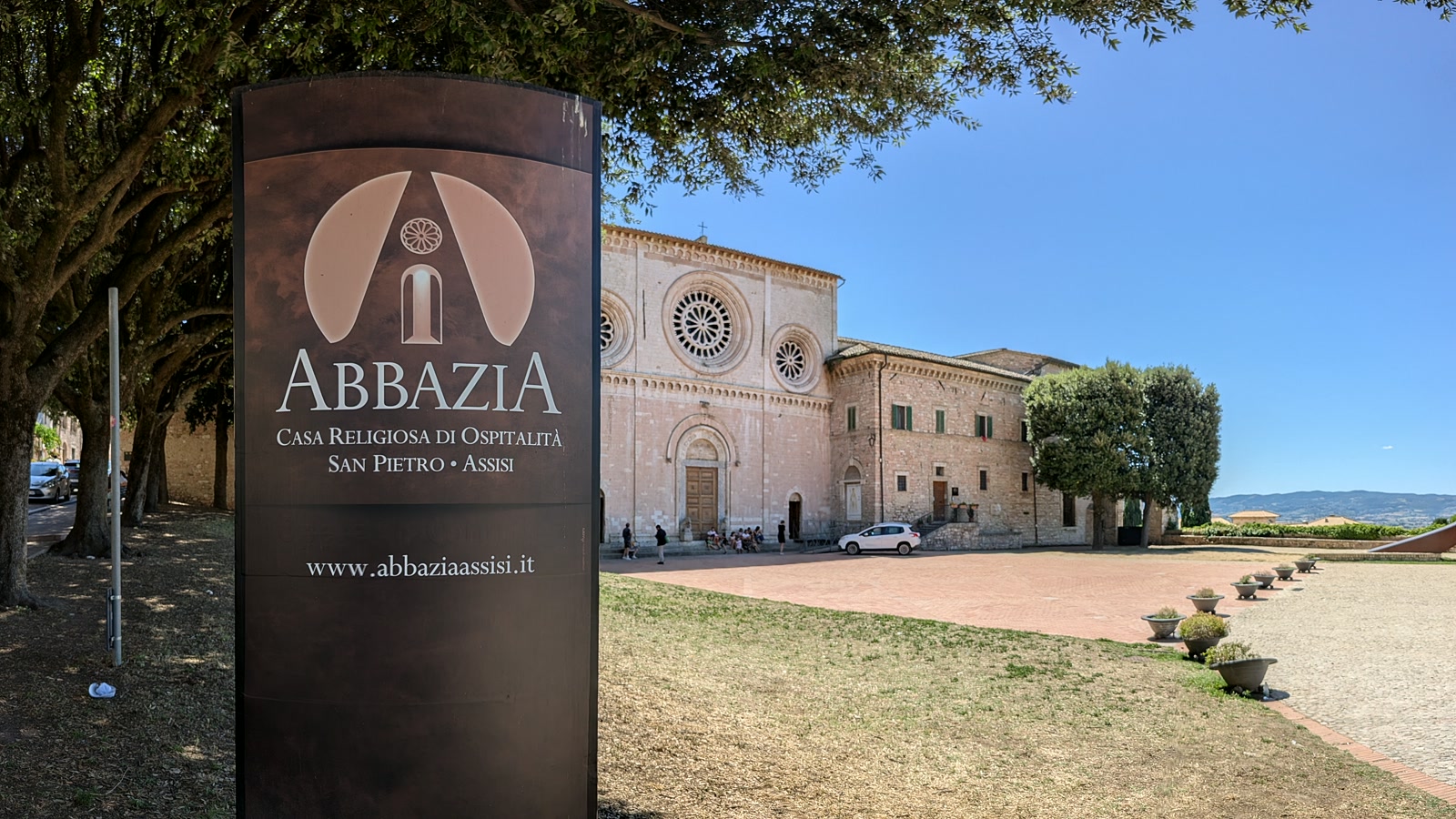The sign for Abbazia San Pietro beside the church and piazza