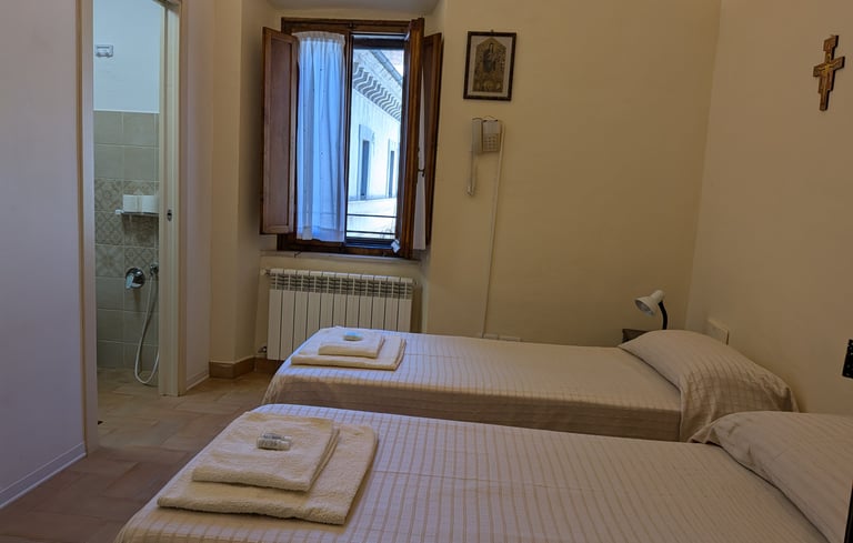 A light twin room prepared with towels